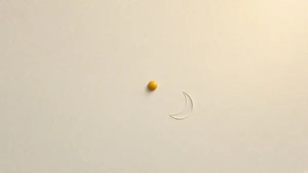 A single small amber drop with a faint swipe of serum on cream paper